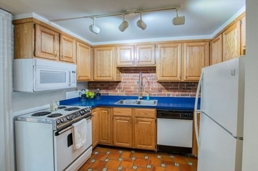 74 Temple Street, Unit 1 Springfield, MA 01105 - Photo 9 of 11 a kitchen with stainless steel appliances granite countertop a refrigerator a sink dishwasher a stove and white countertops with wooden floor