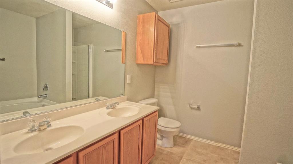 12005 Arbor Lake Road Rhome, TX 76078 - Photo 12 of 22 Bathroom featuring double vanity, a textured wall, tub / shower combination, and tile patterned flooring