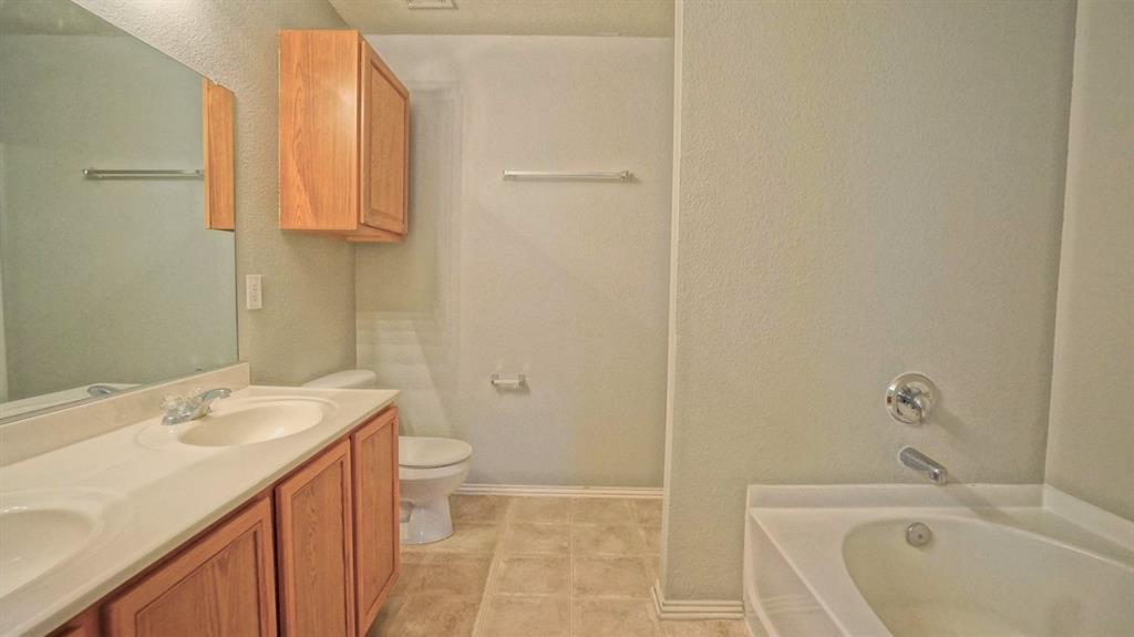 12005 Arbor Lake Road Rhome, TX 76078 - Photo 13 of 22 Full bath featuring a bath, a textured wall, double vanity, and tile patterned floors