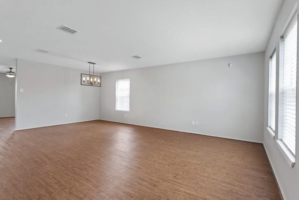 12005 Arbor Lake Road Rhome, TX 76078 - Photo 5 of 22 Spare room with a chandelier, wood finished floors, and a ceiling fan