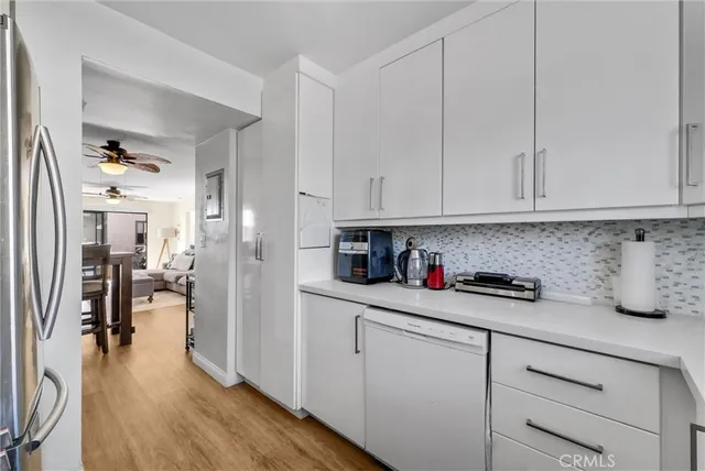 a kitchen with stainless steel appliances granite countertop a refrigerator and white cabinets