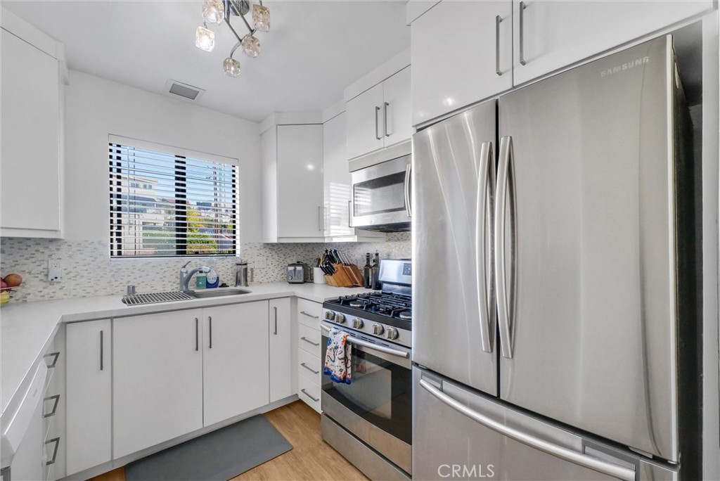 24351 Pasto Road Dana Point, CA 92629 - Photo 9 of 30 a kitchen with stainless steel appliances a refrigerator sink and cabinets