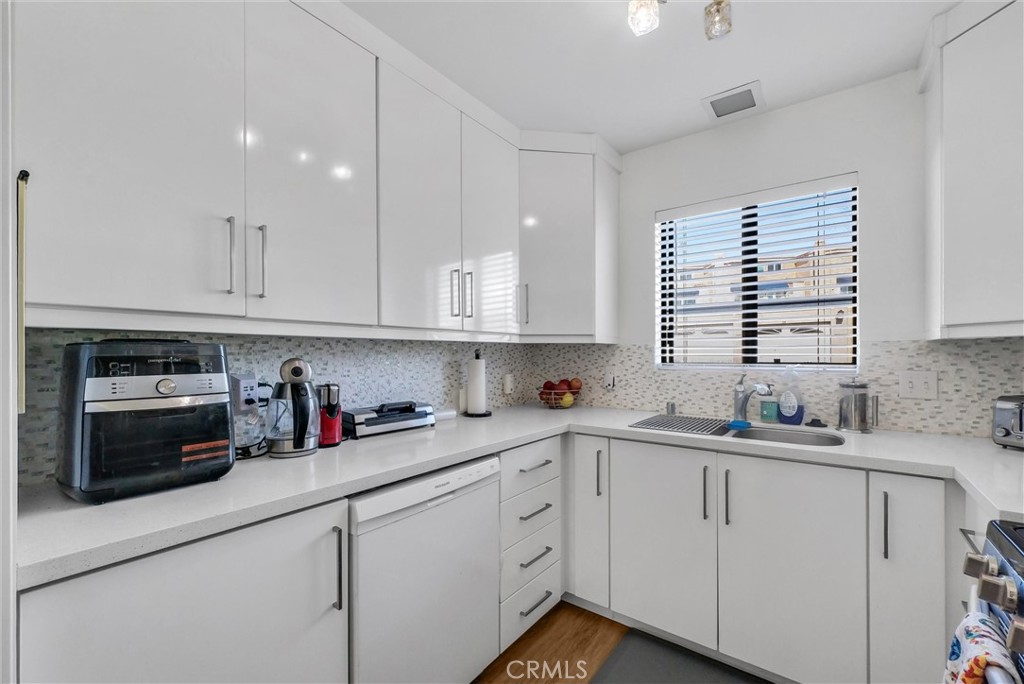 24351 Pasto Road Dana Point, CA 92629 - Photo 10 of 30 a kitchen with white cabinets white appliances and sink