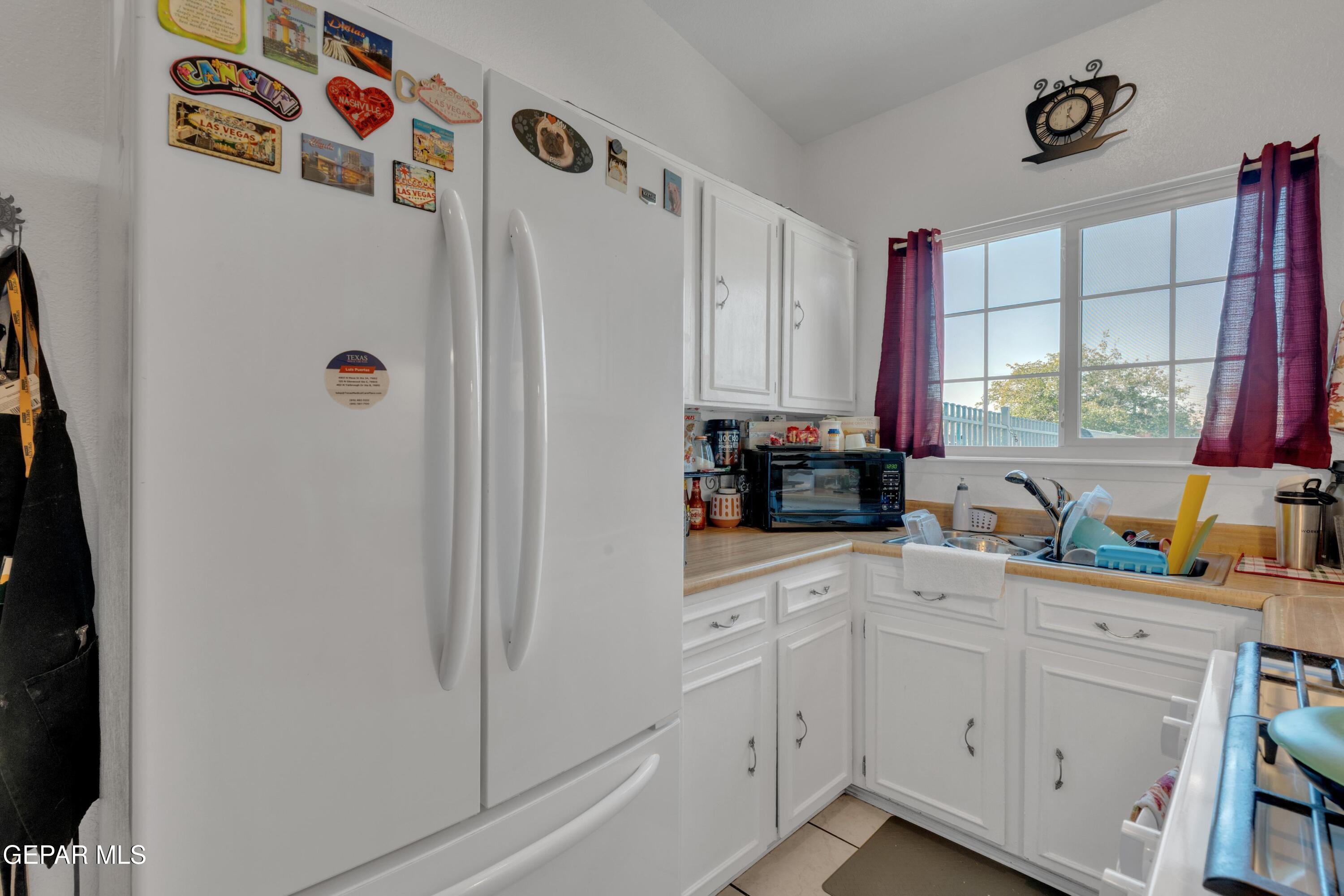 810 Silvestre Road El Paso, TX 79907 - Photo 15 of 33 a kitchen with white cabinets and white appliances