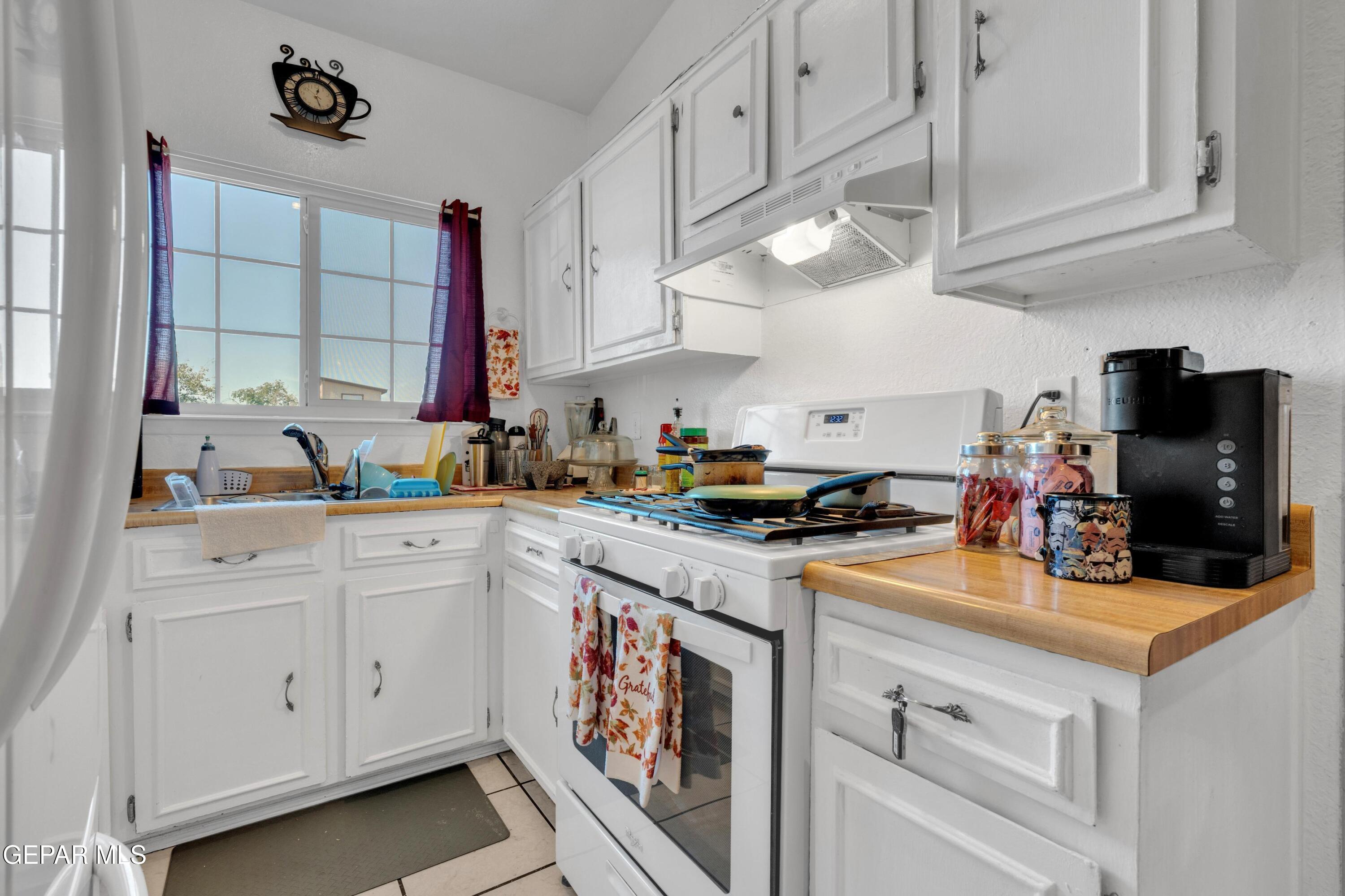 810 Silvestre Road El Paso, TX 79907 - Photo 16 of 33 a kitchen with white cabinets and appliances
