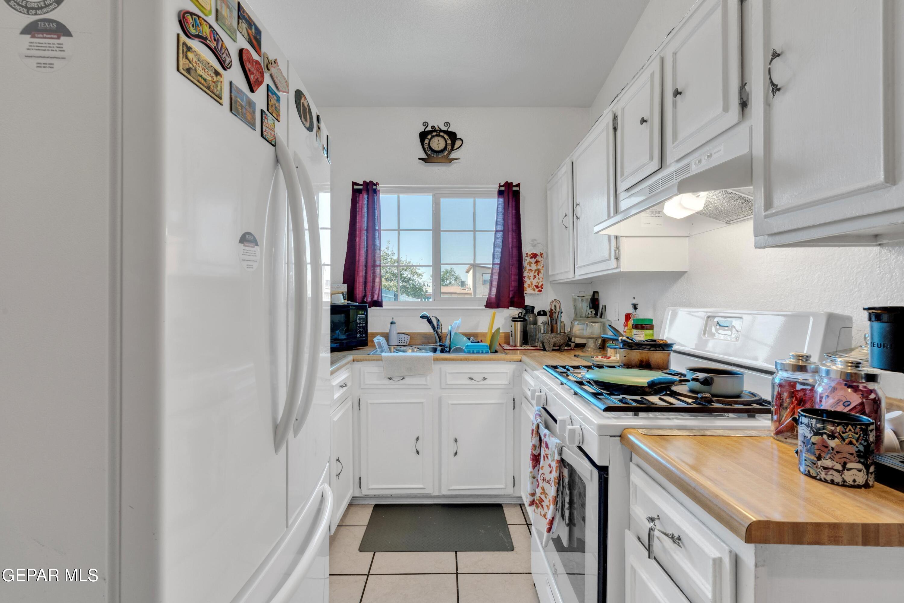 810 Silvestre Road El Paso, TX 79907 - Photo 17 of 33 a kitchen with cabinets a stove a sink and a refrigerator