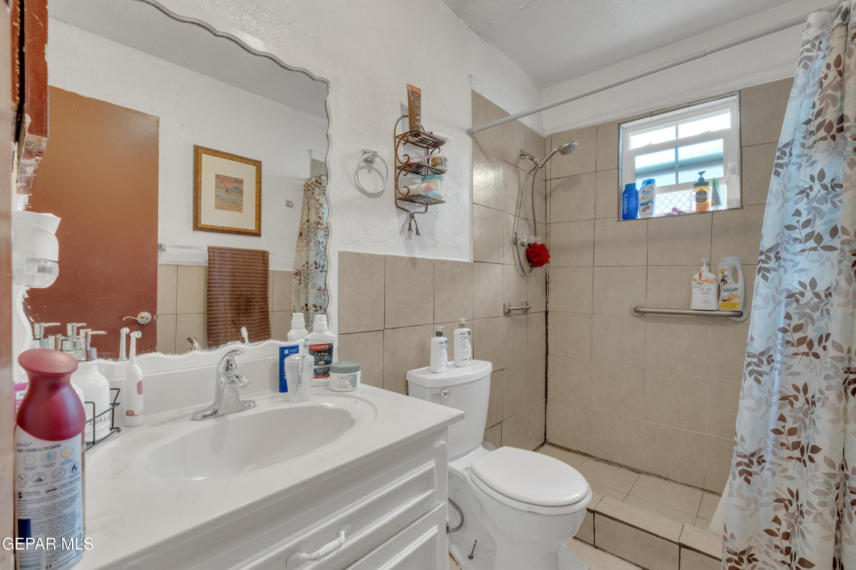810 Silvestre Road El Paso, TX 79907 - Photo 22 of 33 a bathroom with a sink a toilet and a mirror