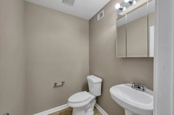 a bathroom with a sink a toilet and mirror