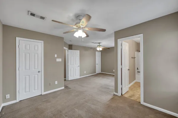 a view of a room with a ceiling fan and a bathroom
