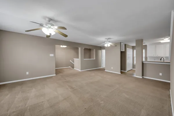 a view of an empty room with a kitchen