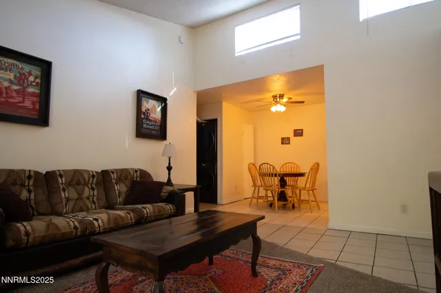 a living room with furniture and a dining table with garden view