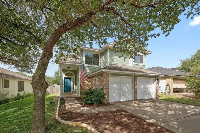 front view of a house with a tree in a yard