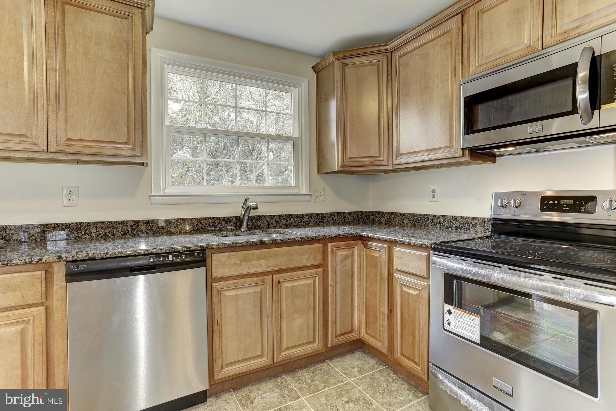 5010 Durham Road East Columbia, MD 21044 - Photo 8 of 30 a kitchen with stainless steel appliances granite countertop a sink stove and microwave