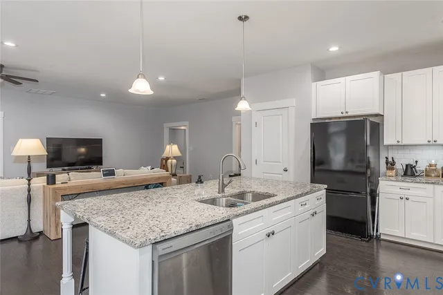 a kitchen with a sink a center island and stainless steel appliances