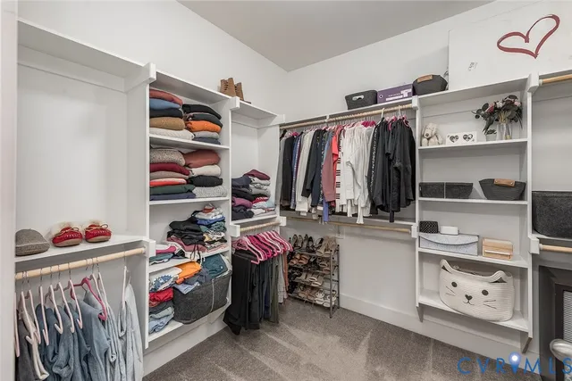 a view of walk in closet with clothes and shoes