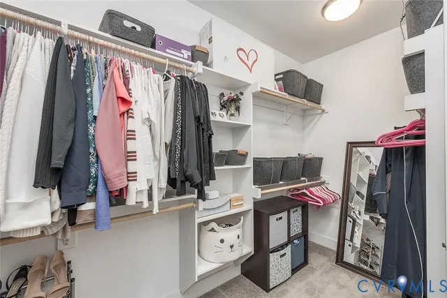 a view of walk in closet with clothes and shoes