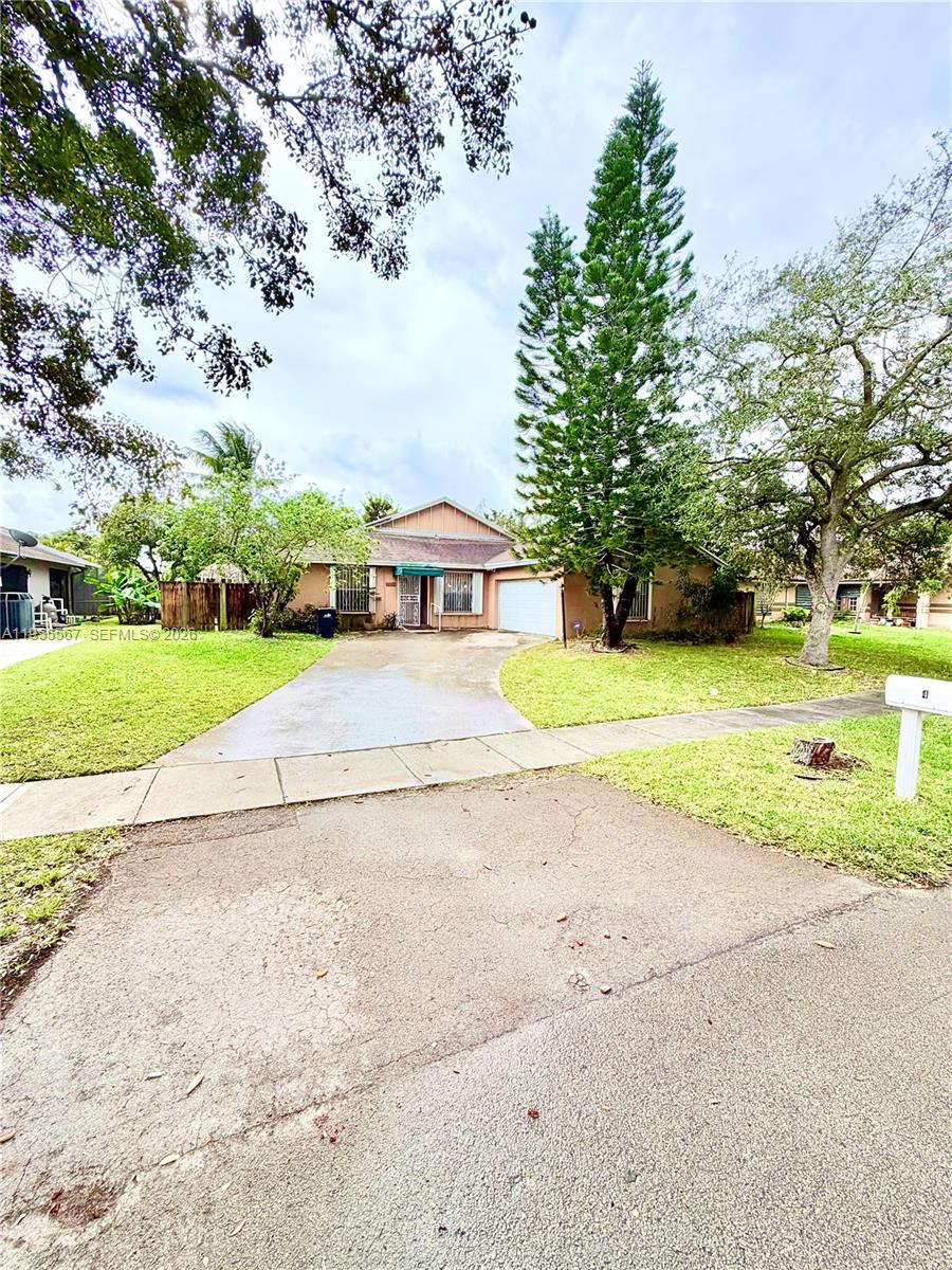 a view of a house with a big yard and large trees