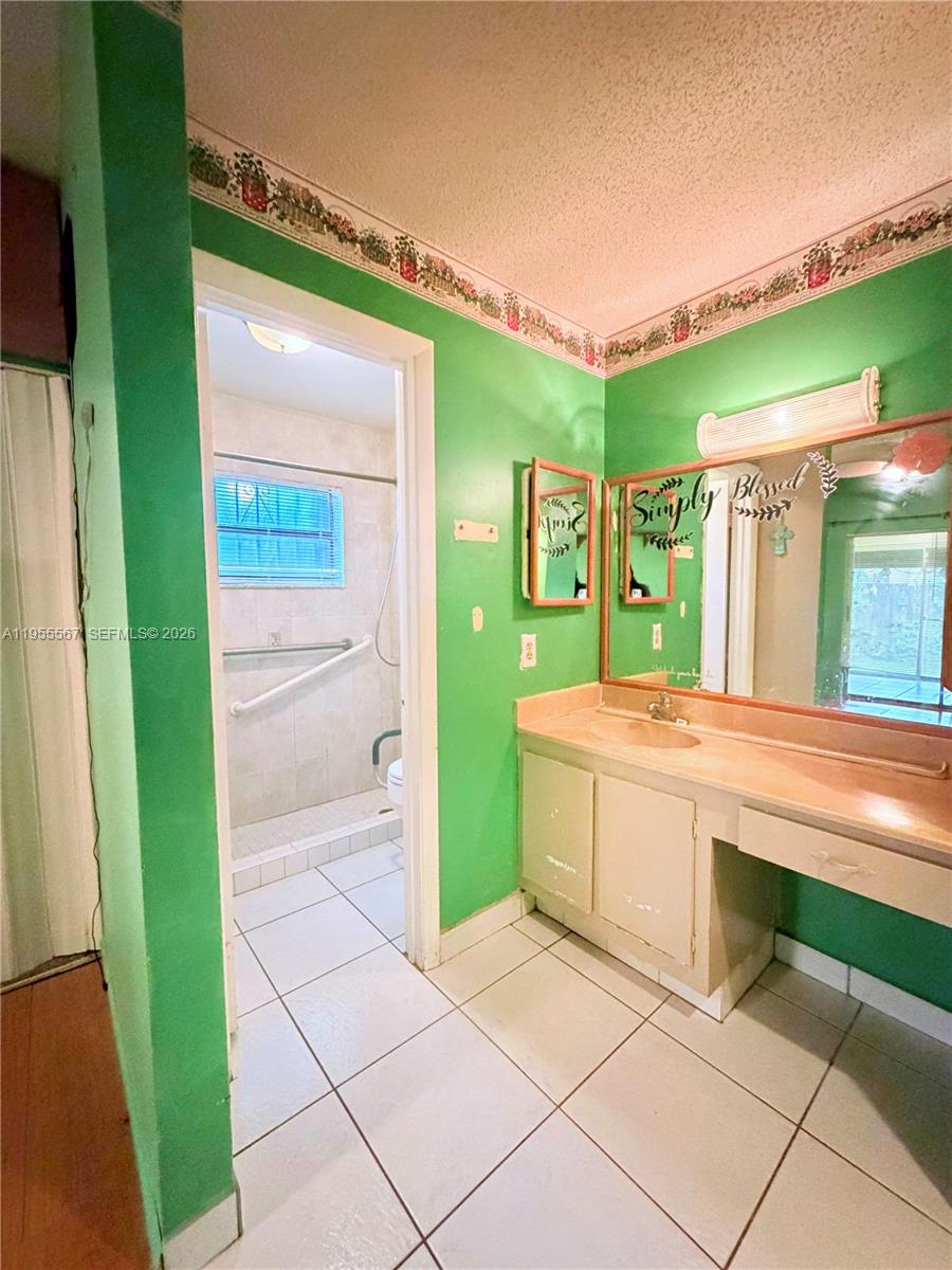 11334 Southwest 152nd Terrace Miami, FL 33157 - Photo 12 of 20 a spacious bathroom with a granite countertop sink and a mirror