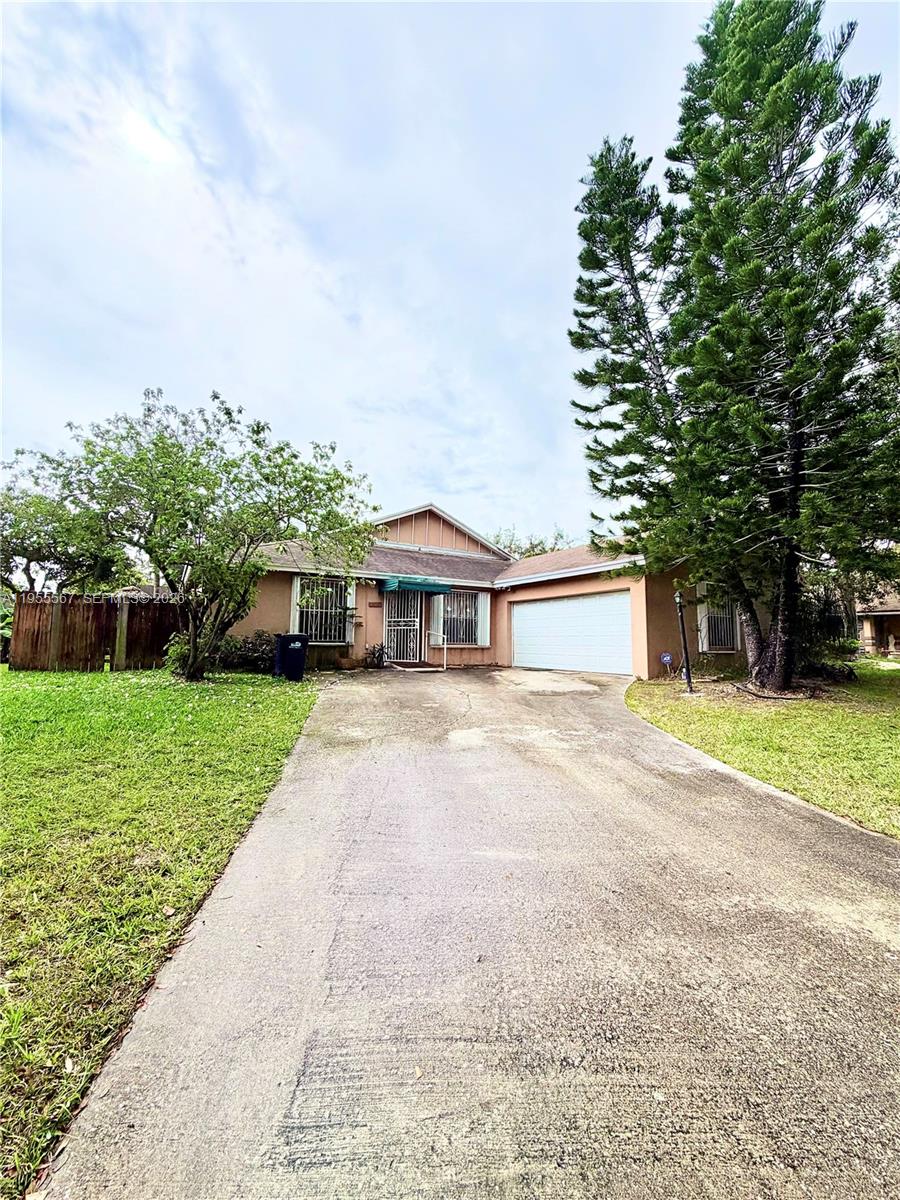 11334 Southwest 152nd Terrace Miami, FL 33157 - Photo 2 of 20 a front view of a house with a yard and garage