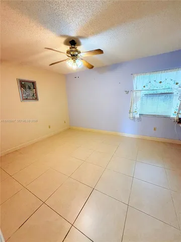 a view of room with a ceiling fan and window