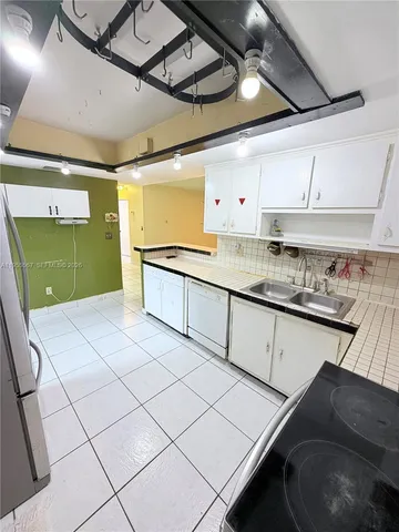 a kitchen with a sink a stove and cabinets