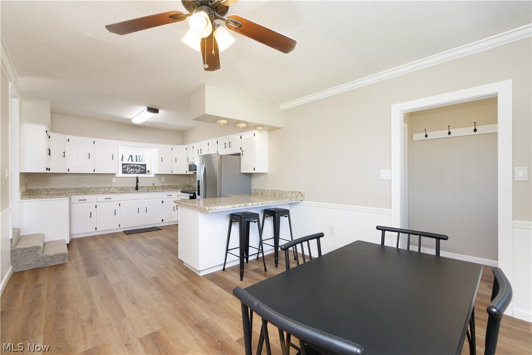 12379 Portage Street Rittman, OH 44270 - Photo 15 of 44 Dining room featuring ornamental molding, sink, ceiling fan, and light wood-type flooring