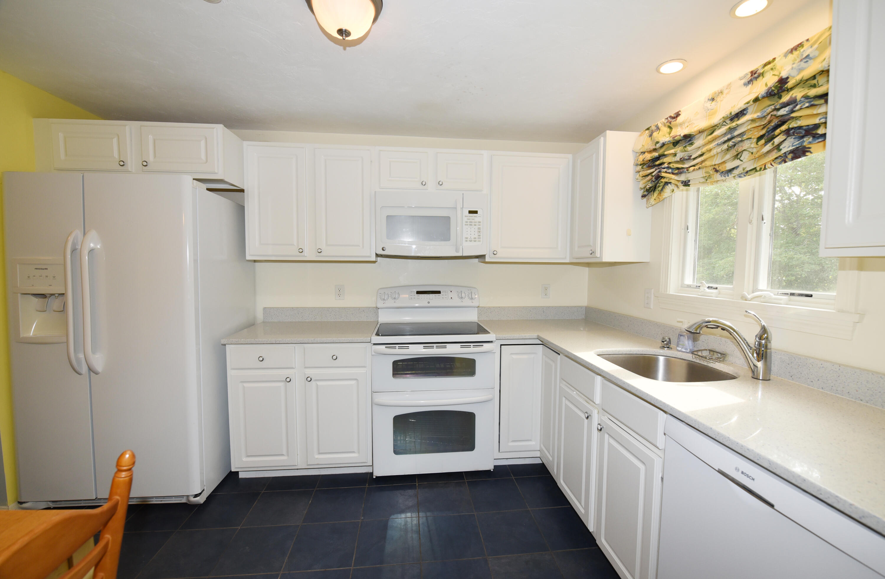 23 North Ridge Road Mashpee, MA 02649 - Photo 5 of 38 a kitchen with white cabinets and a refrigerator