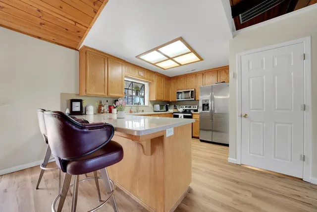 a kitchen with stainless steel appliances granite countertop a sink refrigerator and cabinets