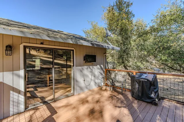 a view of a blue house with a big yard and large trees