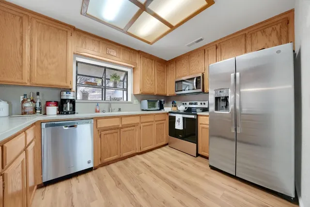 a kitchen with granite countertop stainless steel appliances a refrigerator sink and microwave