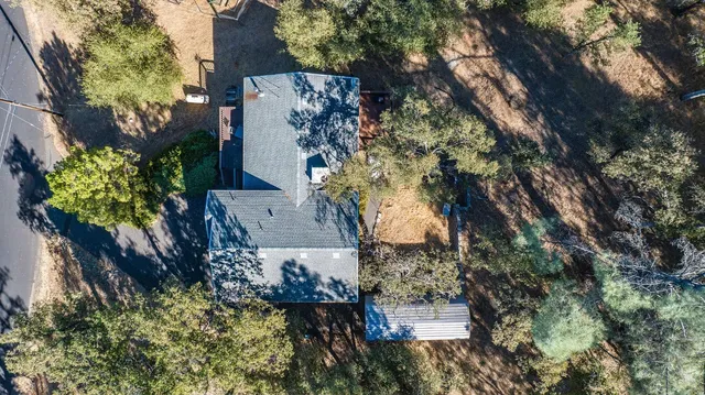 an aerial view of house with yard and mountain in the background