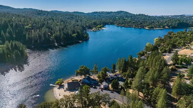 an aerial view of a house with a yard and lake view