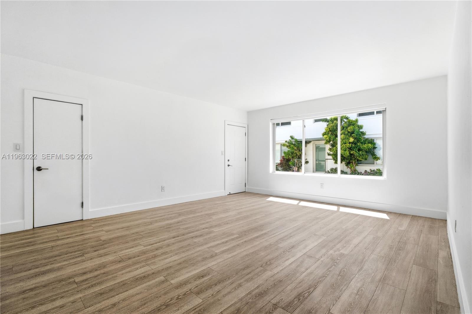 732 82nd Street, Unit 1 Miami Beach, FL 33141 - Photo 1 of 11 an empty room with wooden floor and windows