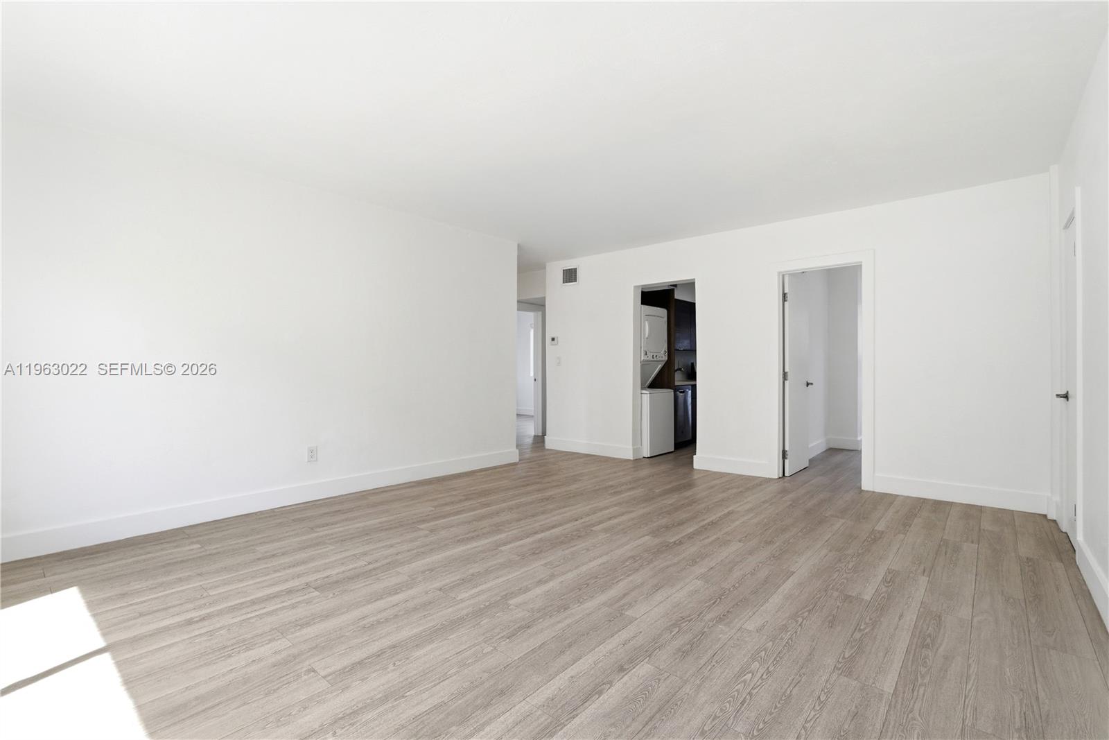 732 82nd Street, Unit 1 Miami Beach, FL 33141 - Photo 3 of 11 a view of an empty room with wooden floor and closet