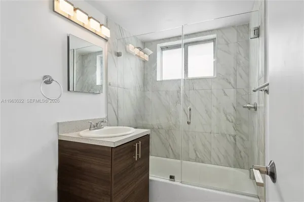 a bathroom with a sink vanity tub and shower
