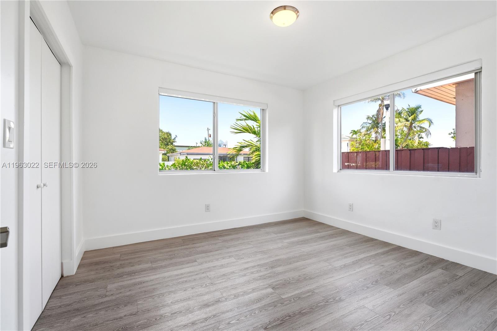 732 82nd Street, Unit 1 Miami Beach, FL 33141 - Photo 6 of 11 an empty room with wooden floor and windows