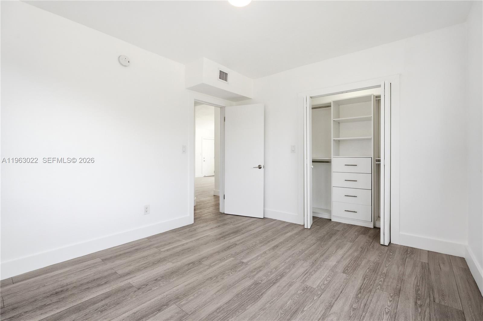 732 82nd Street, Unit 1 Miami Beach, FL 33141 - Photo 7 of 11 an empty room with wooden floor & closet area