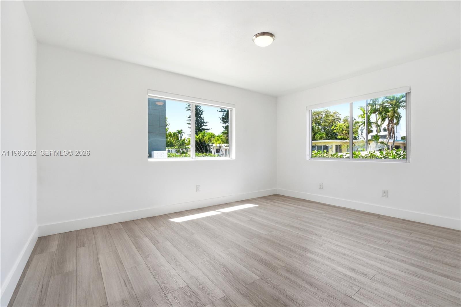 732 82nd Street, Unit 1 Miami Beach, FL 33141 - Photo 8 of 11 an empty room with wooden floor and window