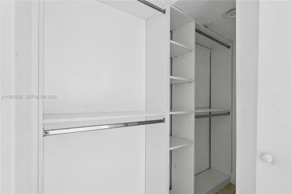 an empty room with window and closet