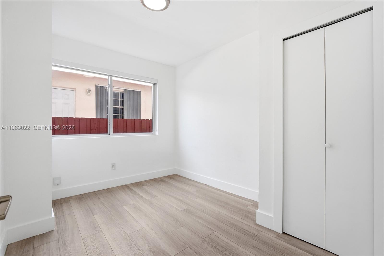 732 82nd Street, Unit 1 Miami Beach, FL 33141 - Photo 10 of 11 an empty room with wooden floor and windows