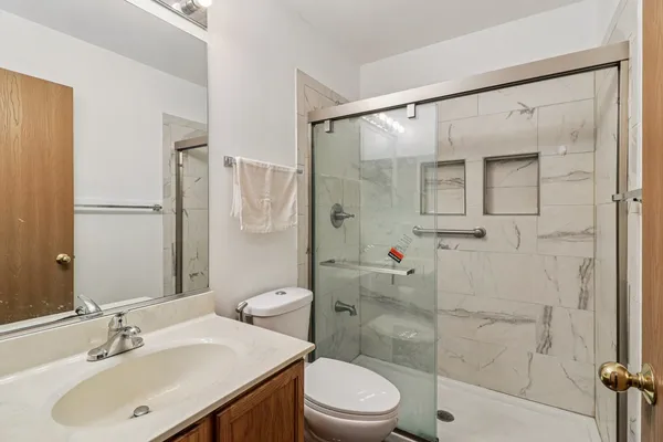 a bathroom with a sink shower and a toilet