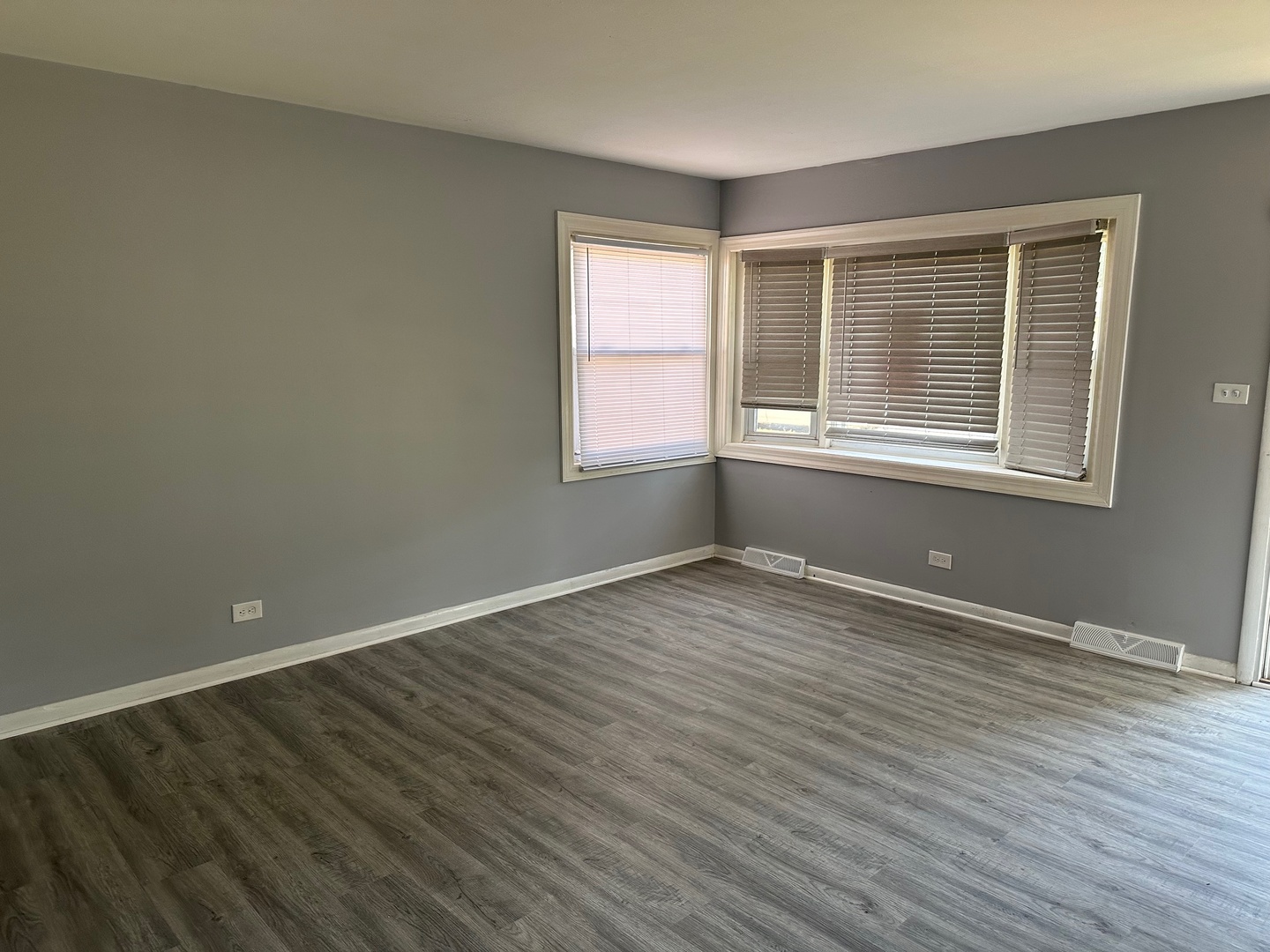 2956 Sherwood Avenue Markham, IL 60428 - Photo 3 of 13 an empty room with wooden floor and windows