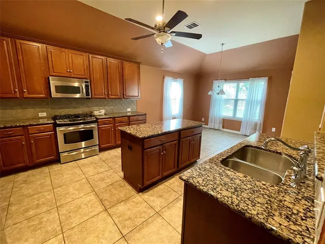 a kitchen with stainless steel appliances granite countertop a sink stove and cabinets
