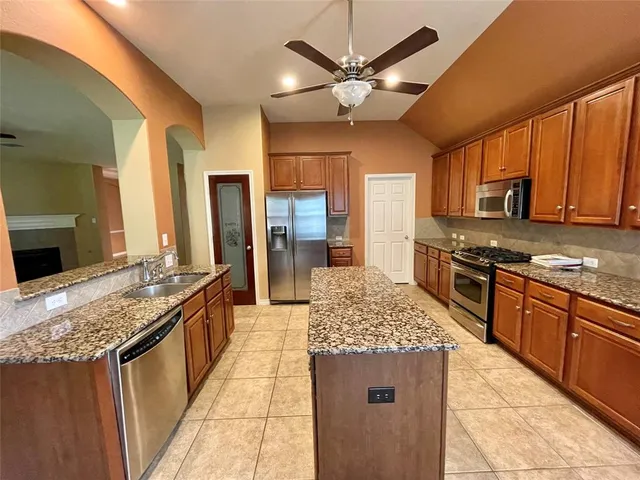 a kitchen with stainless steel appliances granite countertop a sink stove and refrigerator