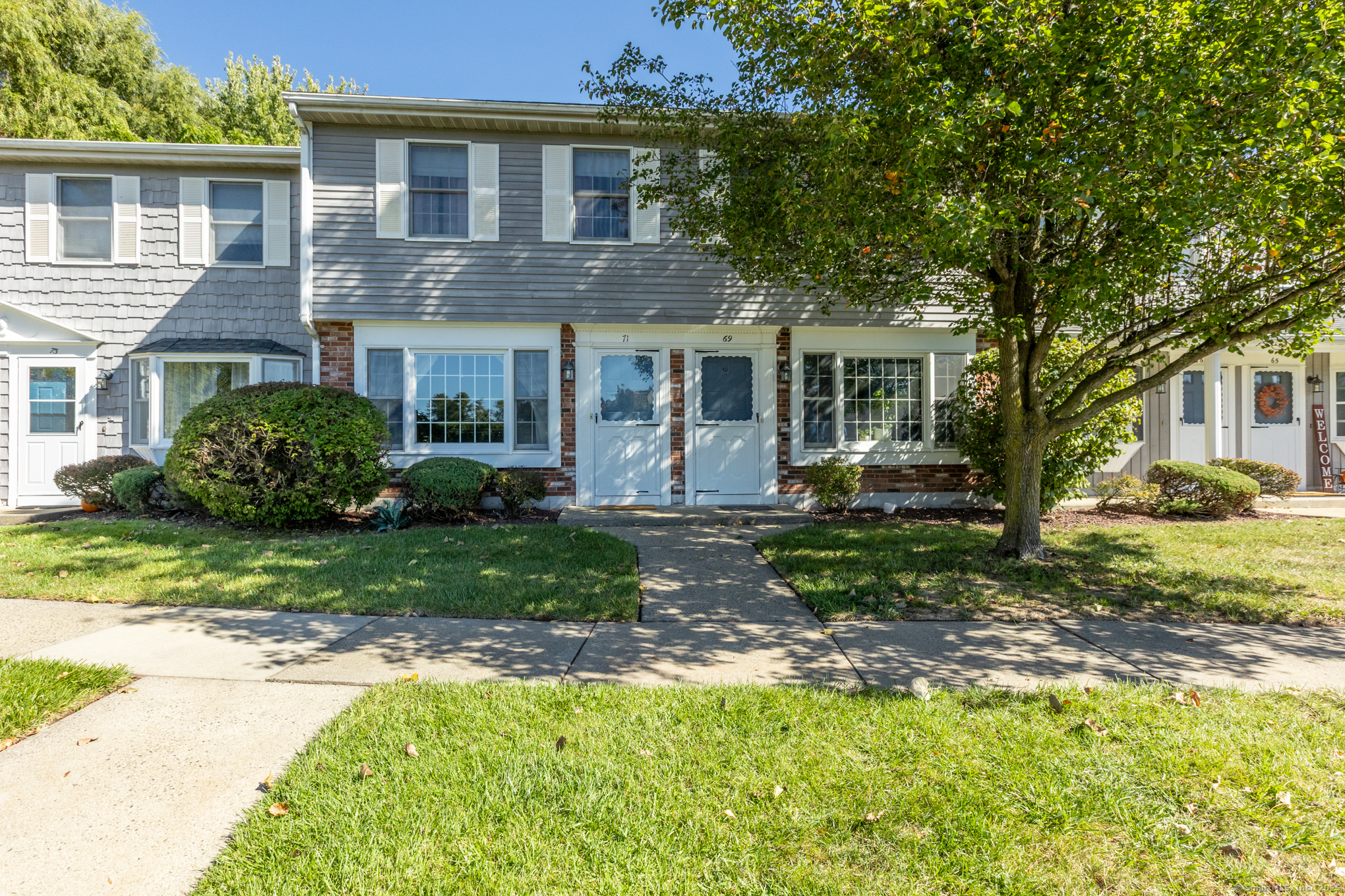 71 Joiners Road, Unit 71 Rocky Hill, CT 06067 - Photo 1 of 1 a front view of a house with a yard and trees