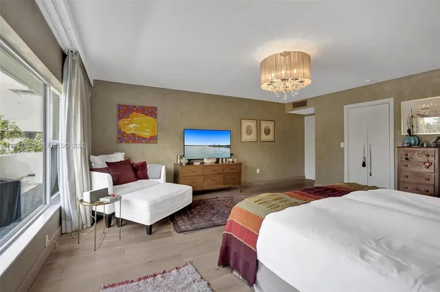 a bedroom with a bed and a chandelier