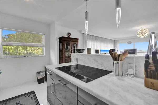 a kitchen with stainless steel appliances granite countertop a sink a counter space and a window