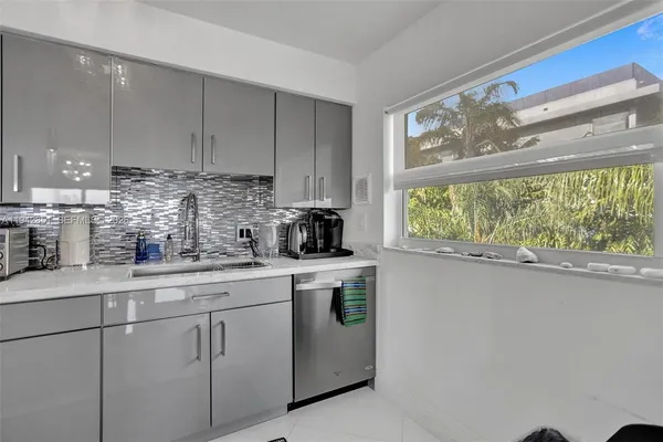 a kitchen with white cabinets and white appliances