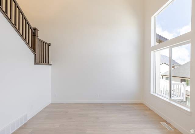 4748 Heartwood Road, Unit 434 Mapleton, UT 84664 - Photo 5 of 18 Empty room with light wood-style flooring and a high ceiling