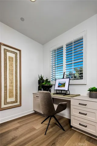 a view of a workspace with furniture and a window